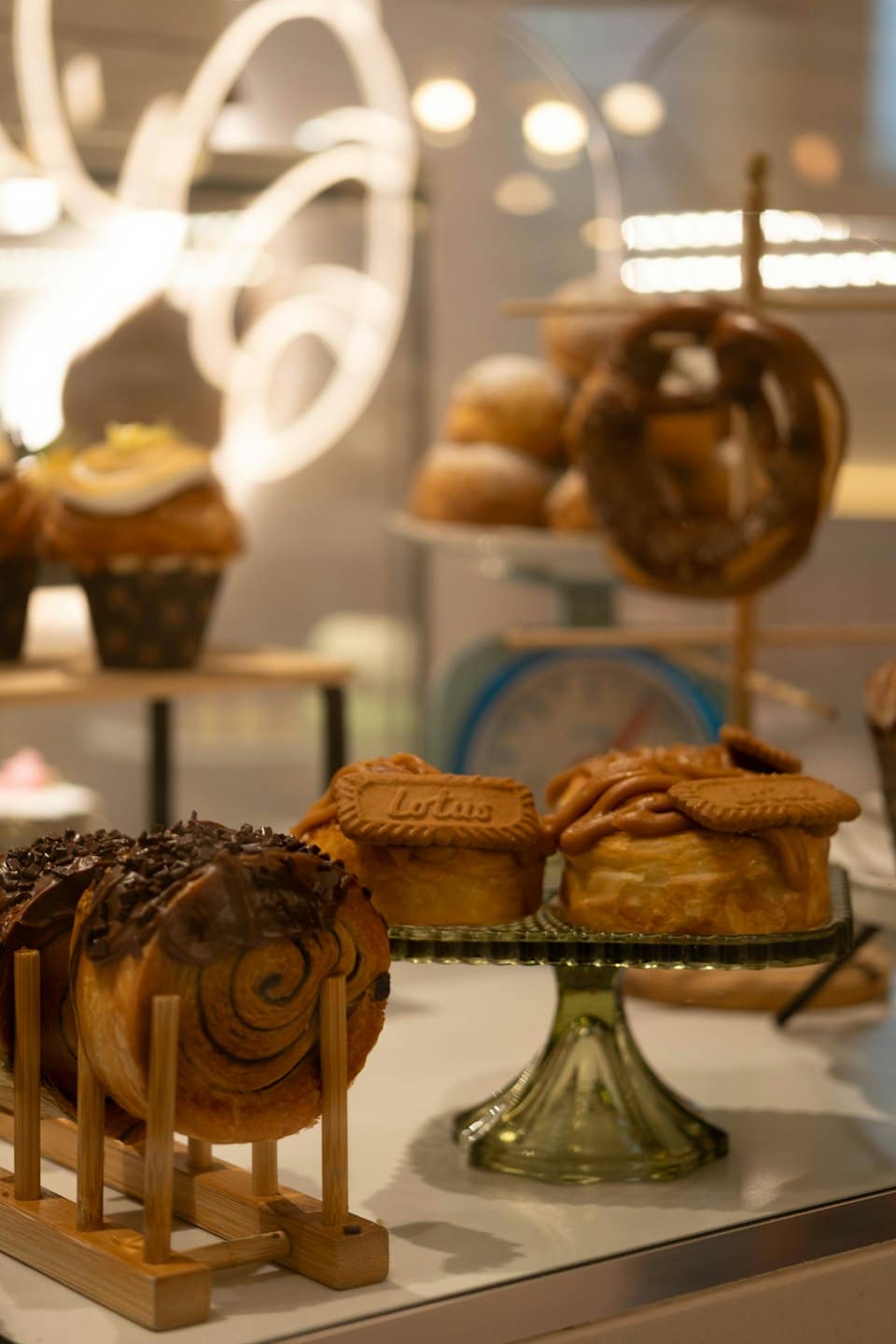 Pasteles variados y rollos de canela expuestos en el mostrador de una panadería.